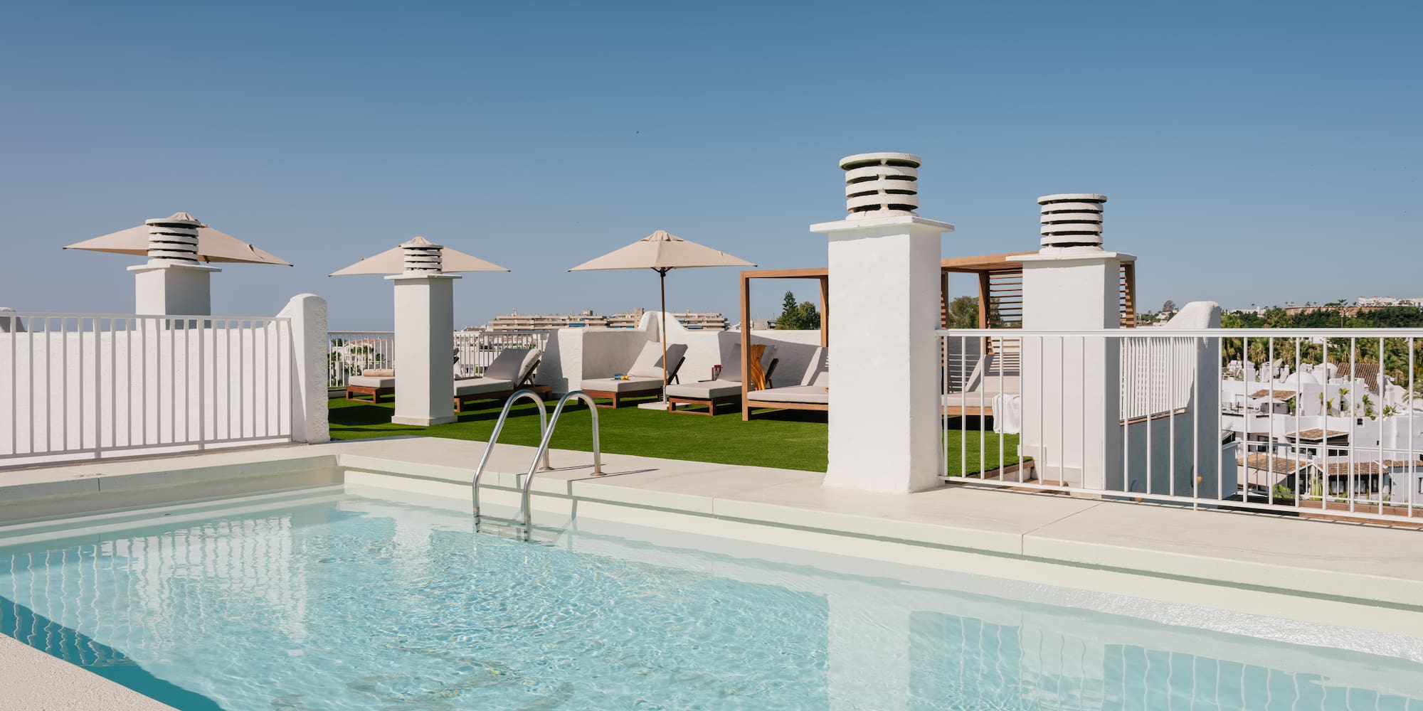 a pool with a white fence and umbrellas