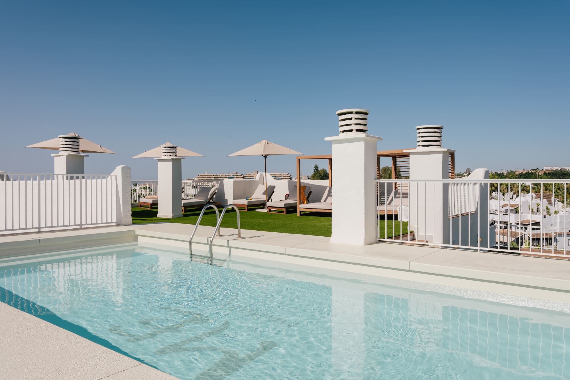 a pool with a white fence and umbrellas