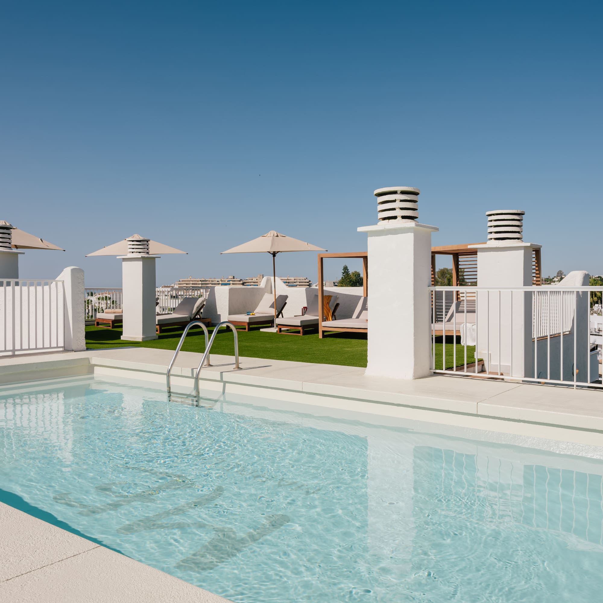a pool with a white fence and umbrellas