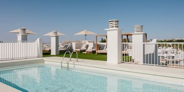 a pool with a white fence and umbrellas