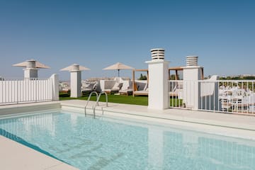 a pool with a white fence and umbrellas