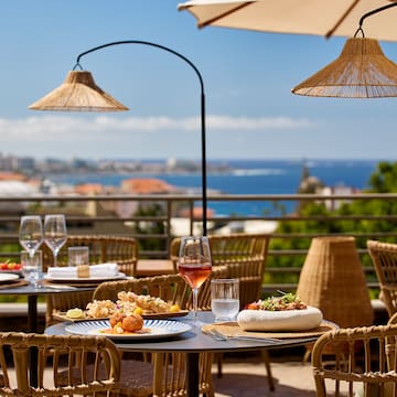 a table with food on it and umbrellas on a balcony