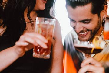 a man and woman holding drinks