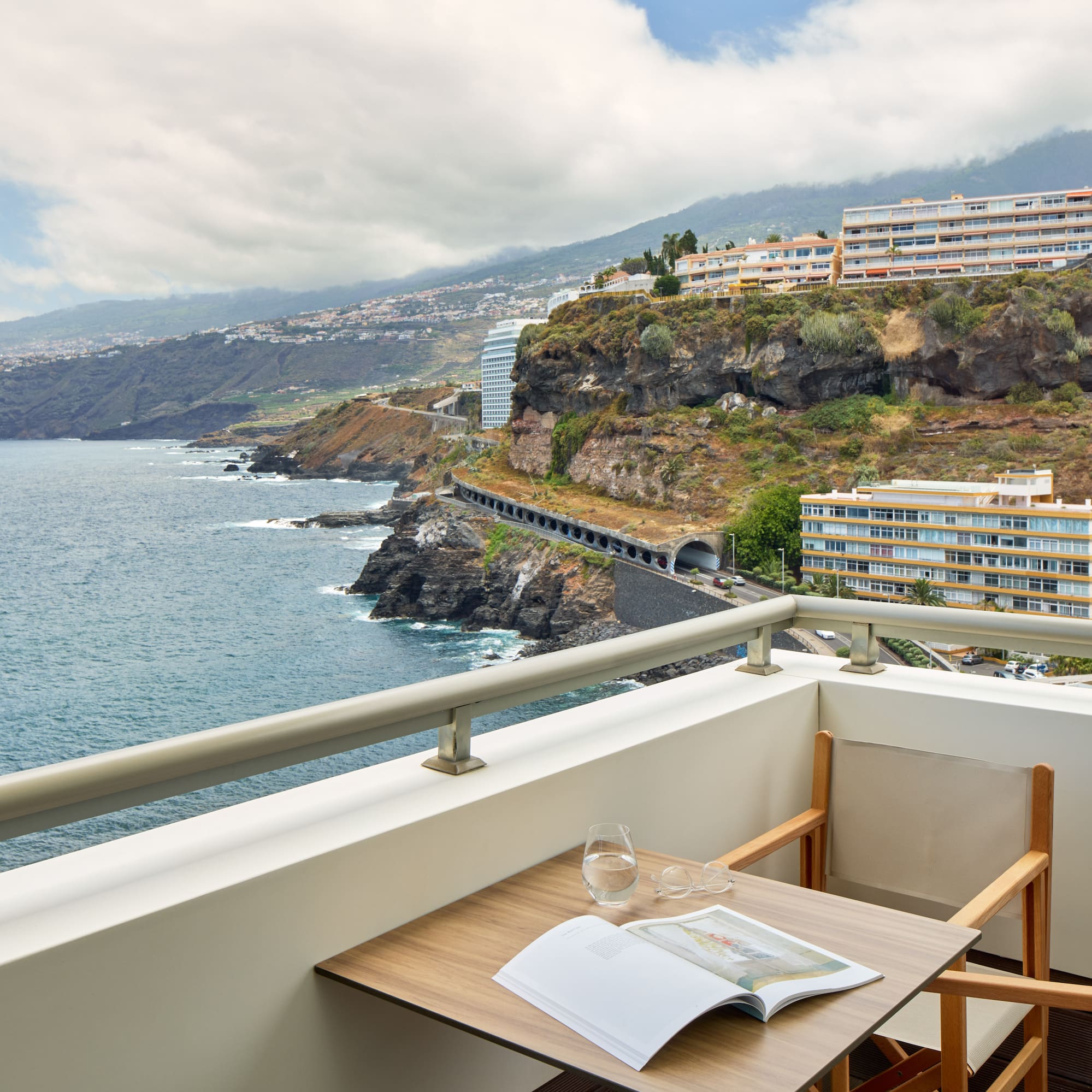 a table and chairs on a balcony overlooking a body of water