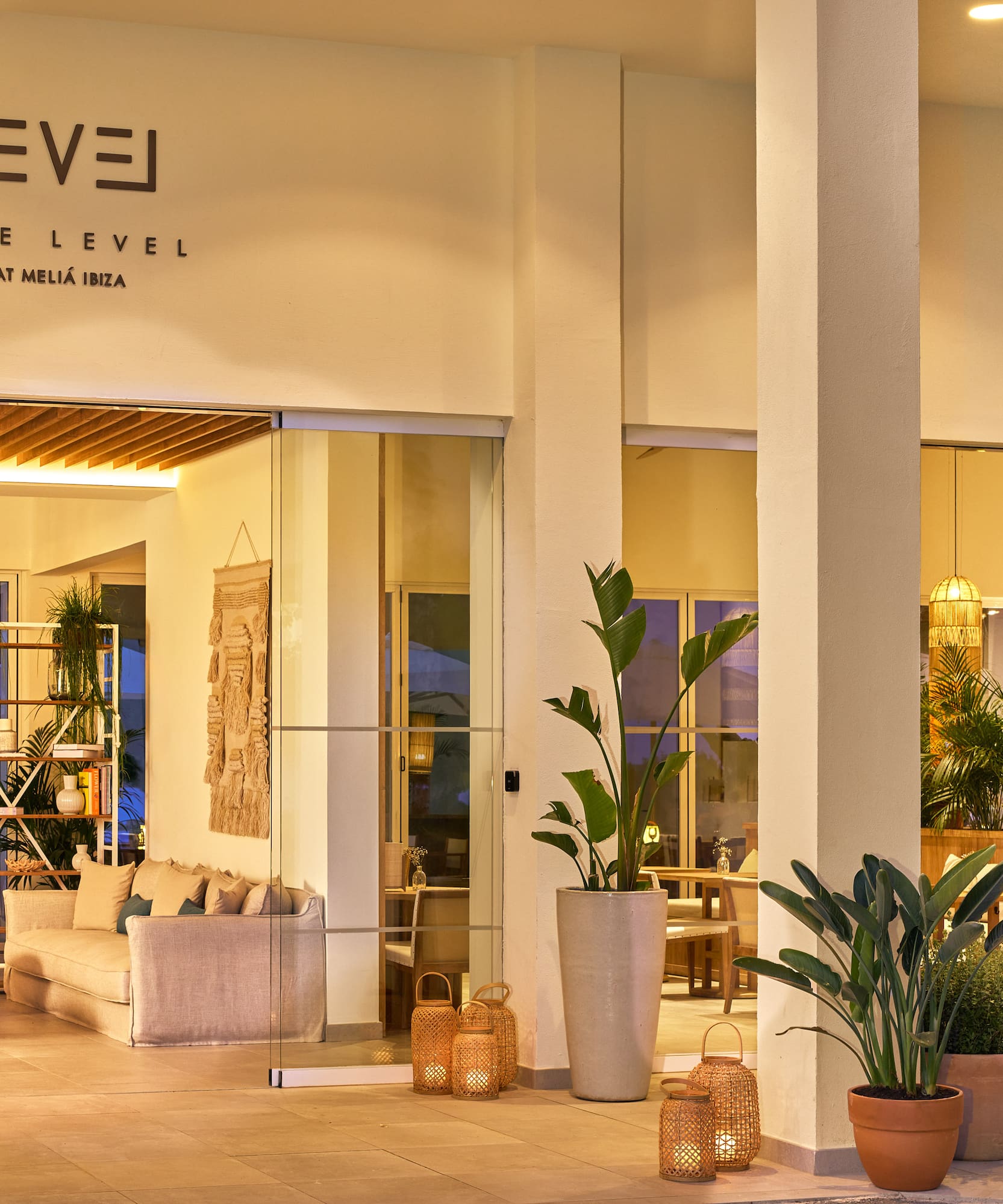 a building with a sign and plants