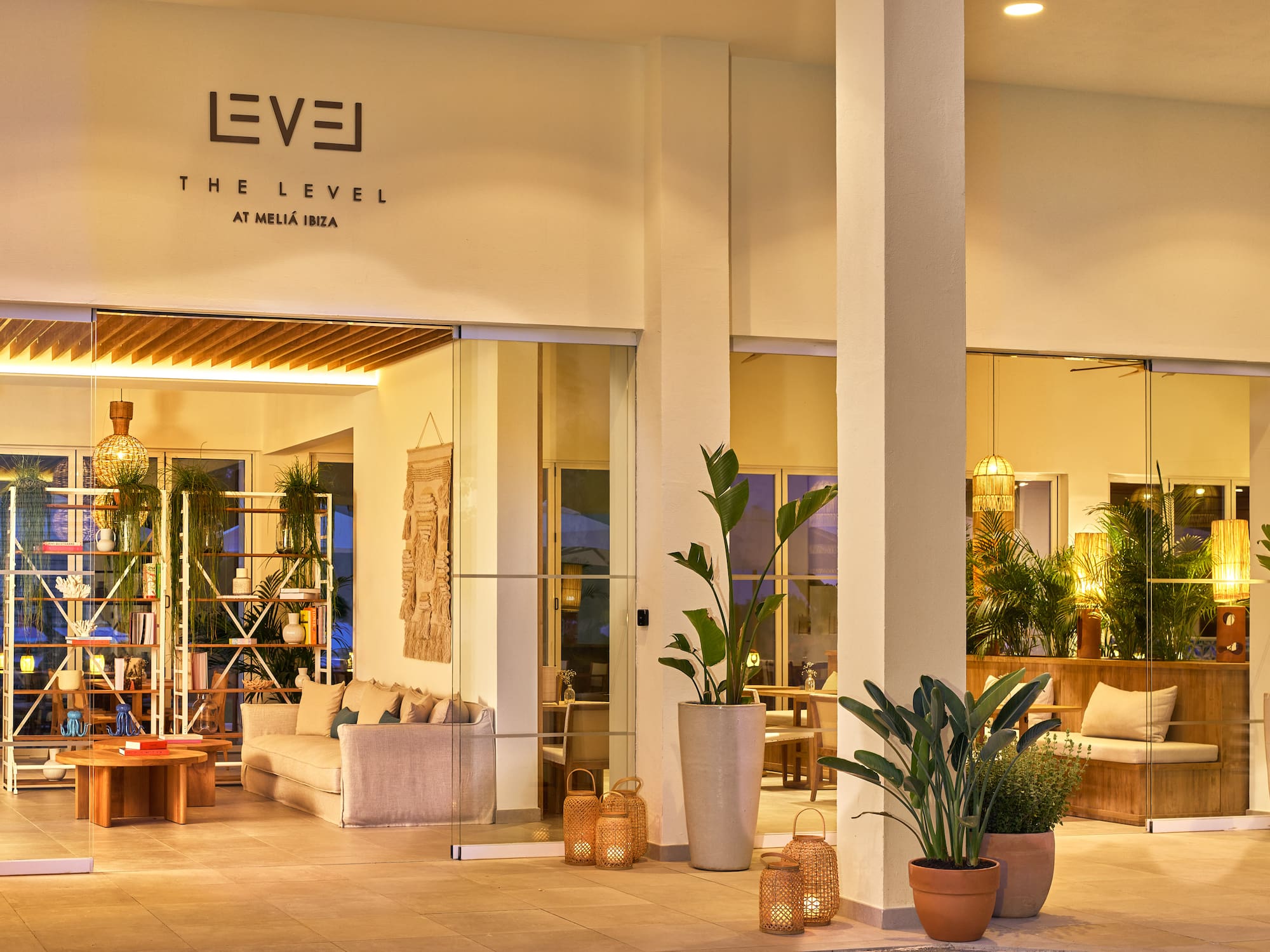 a building with a sign and plants