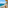 Balcony overlooking turquoise sea, sandy beach, and distant resort town.