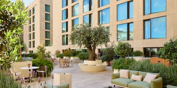 a courtyard with a tree and chairs