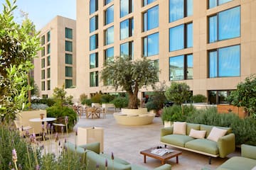 a courtyard with a tree and chairs