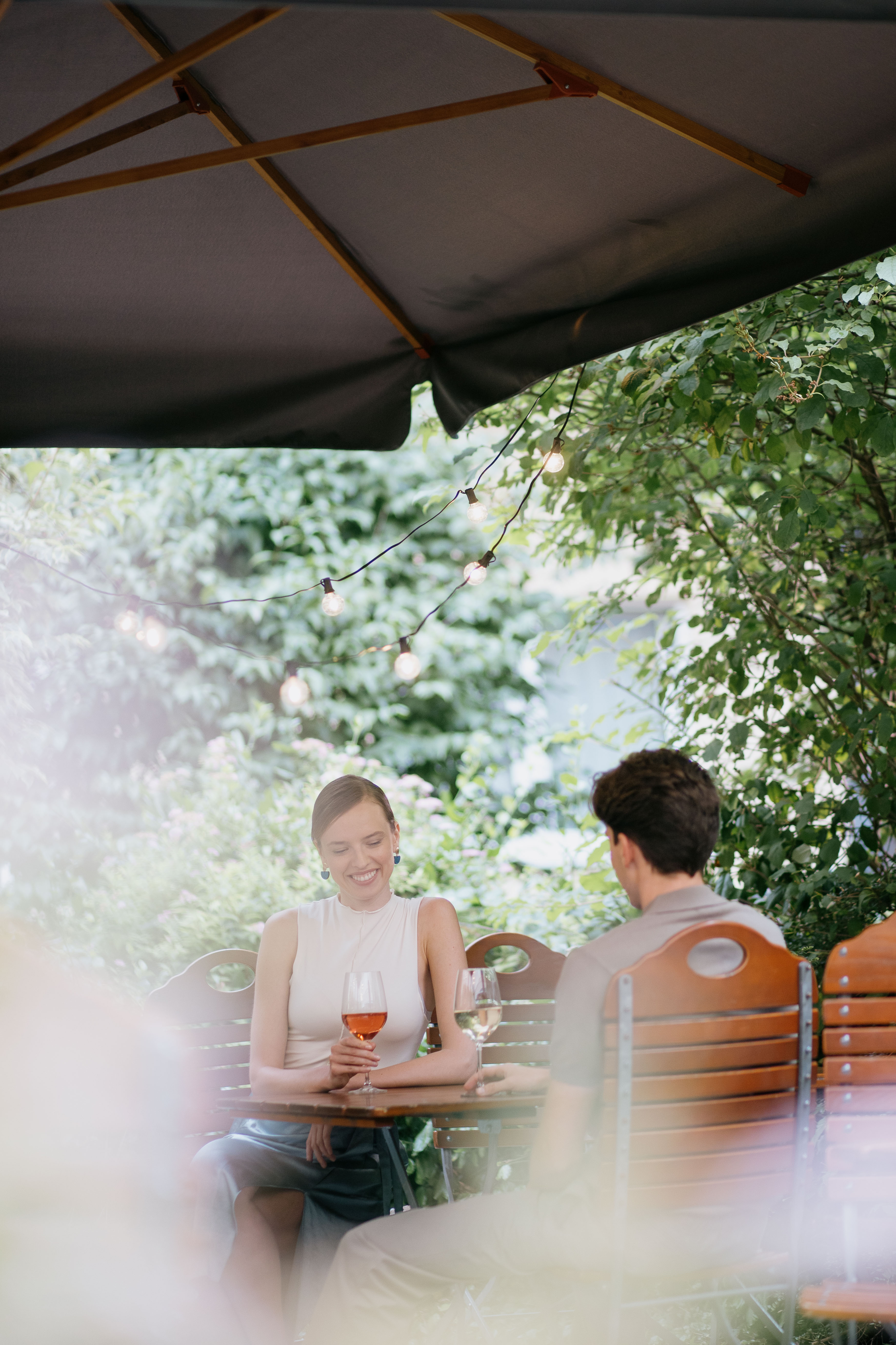 a man and woman sitting at a table with wine glasses