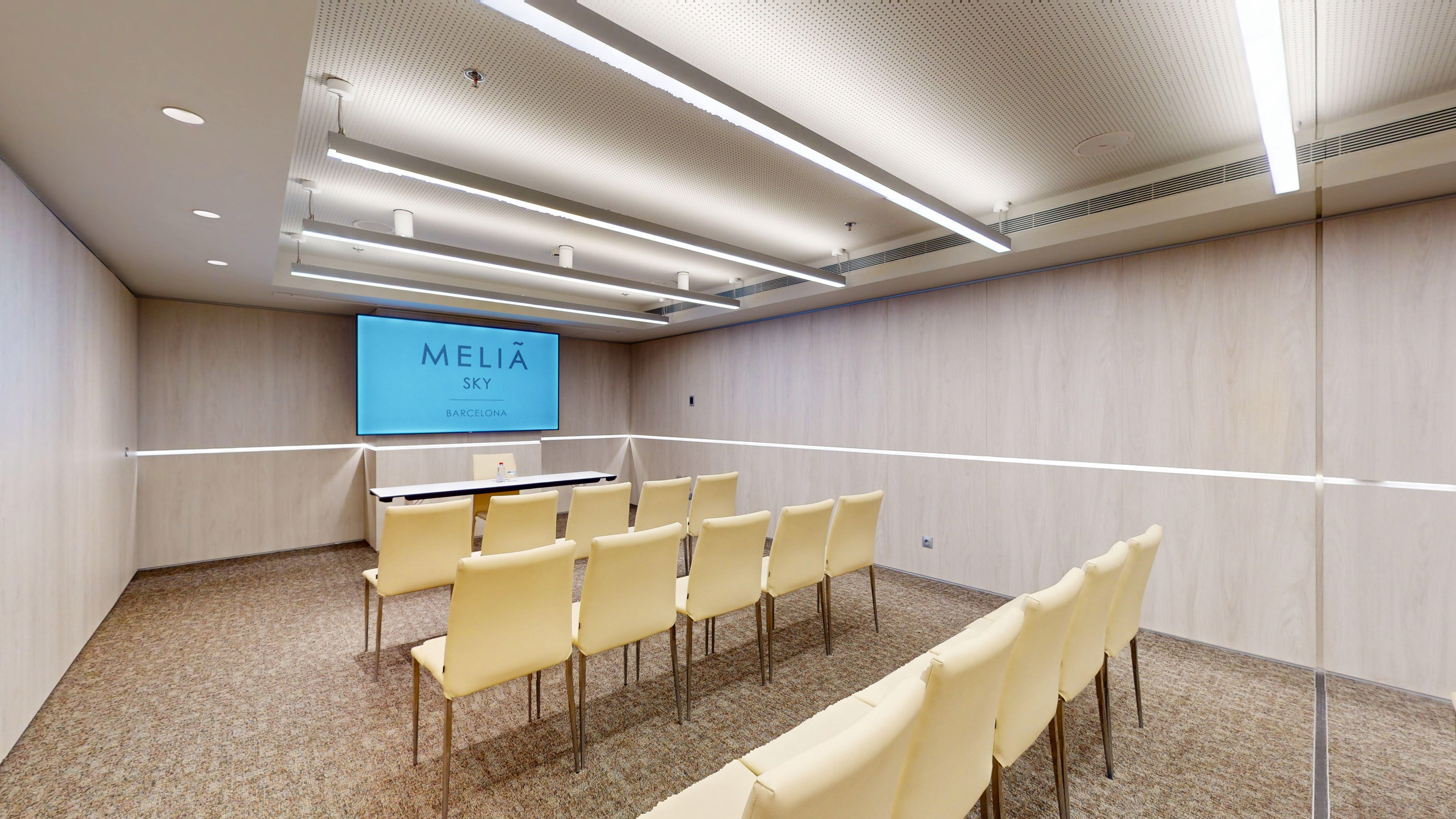 Meliá Sky Barcelona conference room with presentation screen and arranged seating.