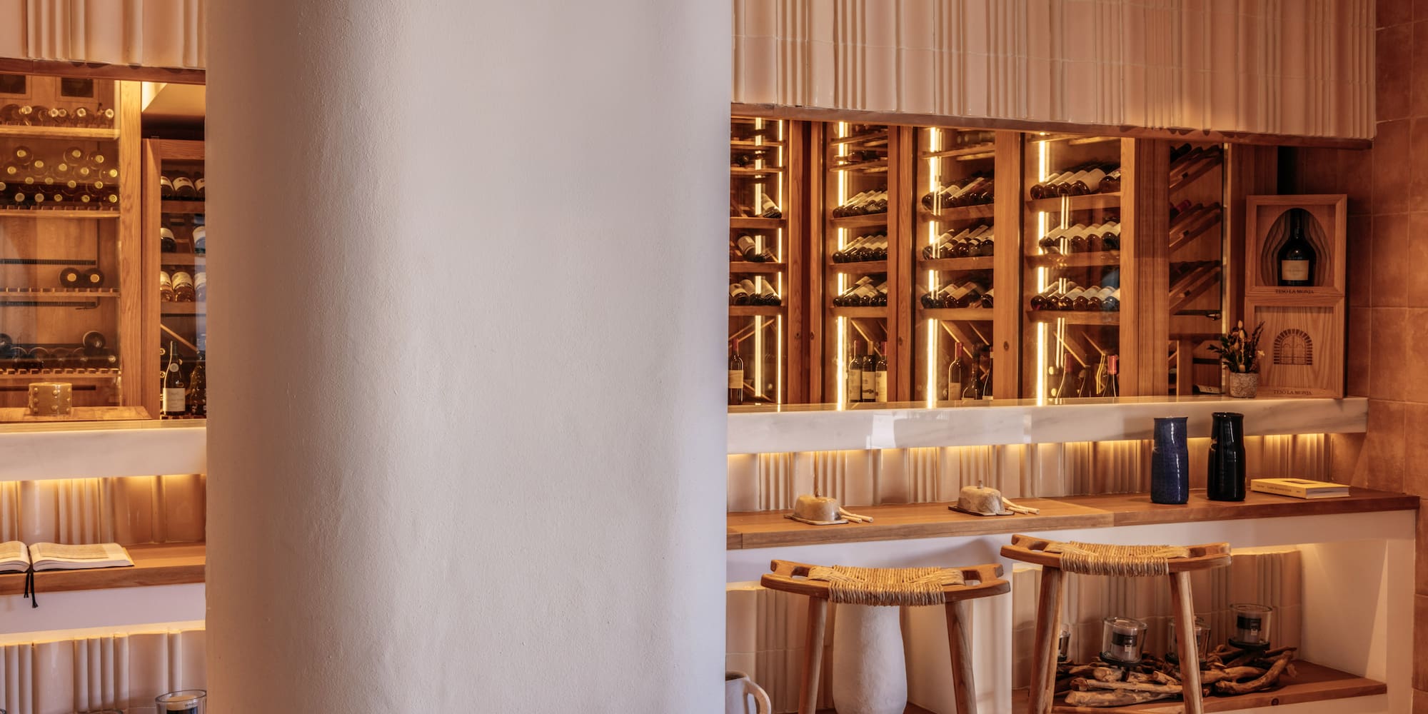 a wine cellar with stools and a shelf with wine bottles