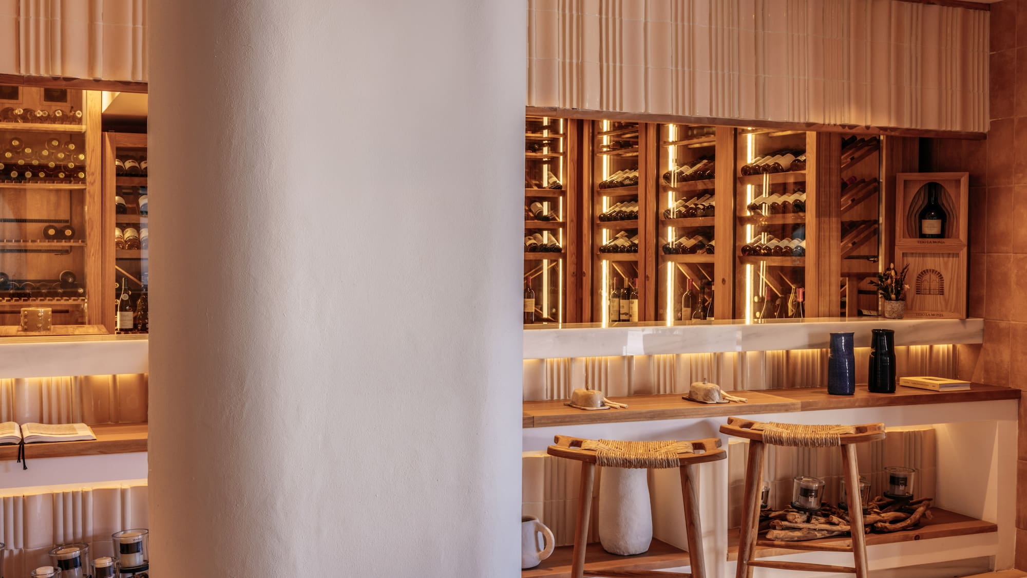 a wine cellar with stools and a shelf with wine bottles
