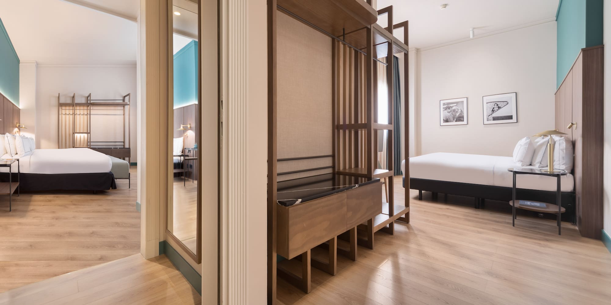 Modern hotel suite with two beds, wooden floor, and open wardrobe.
