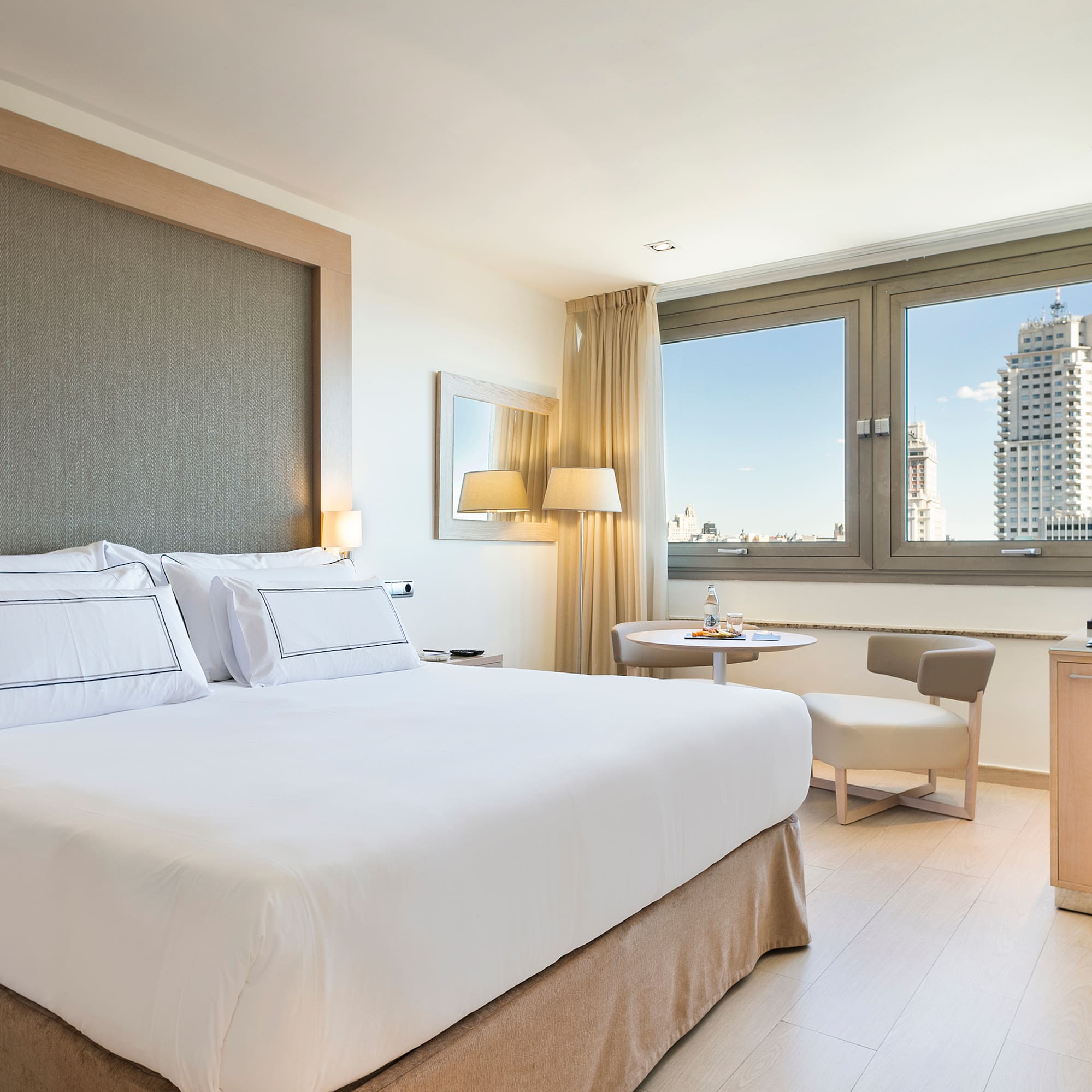 a bedroom with a bed and a table and chairs