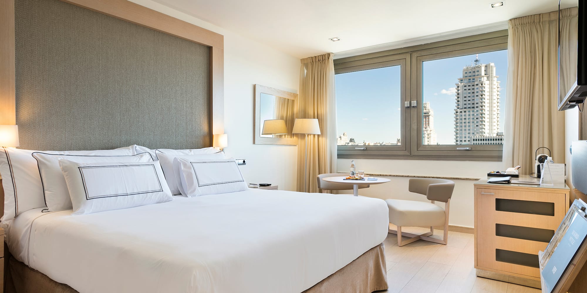 a bedroom with a bed and a table and chairs