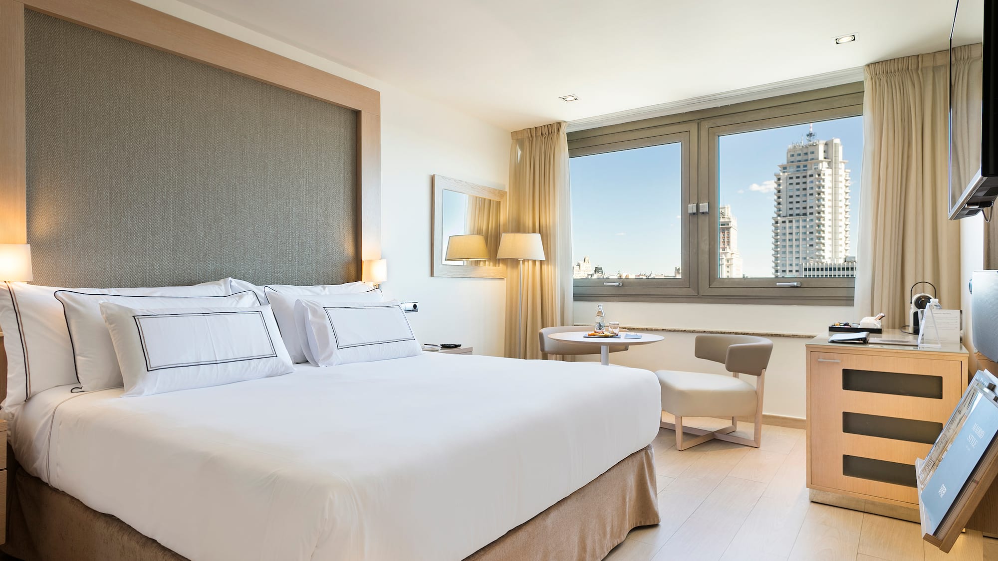 a bedroom with a bed and a table and chairs