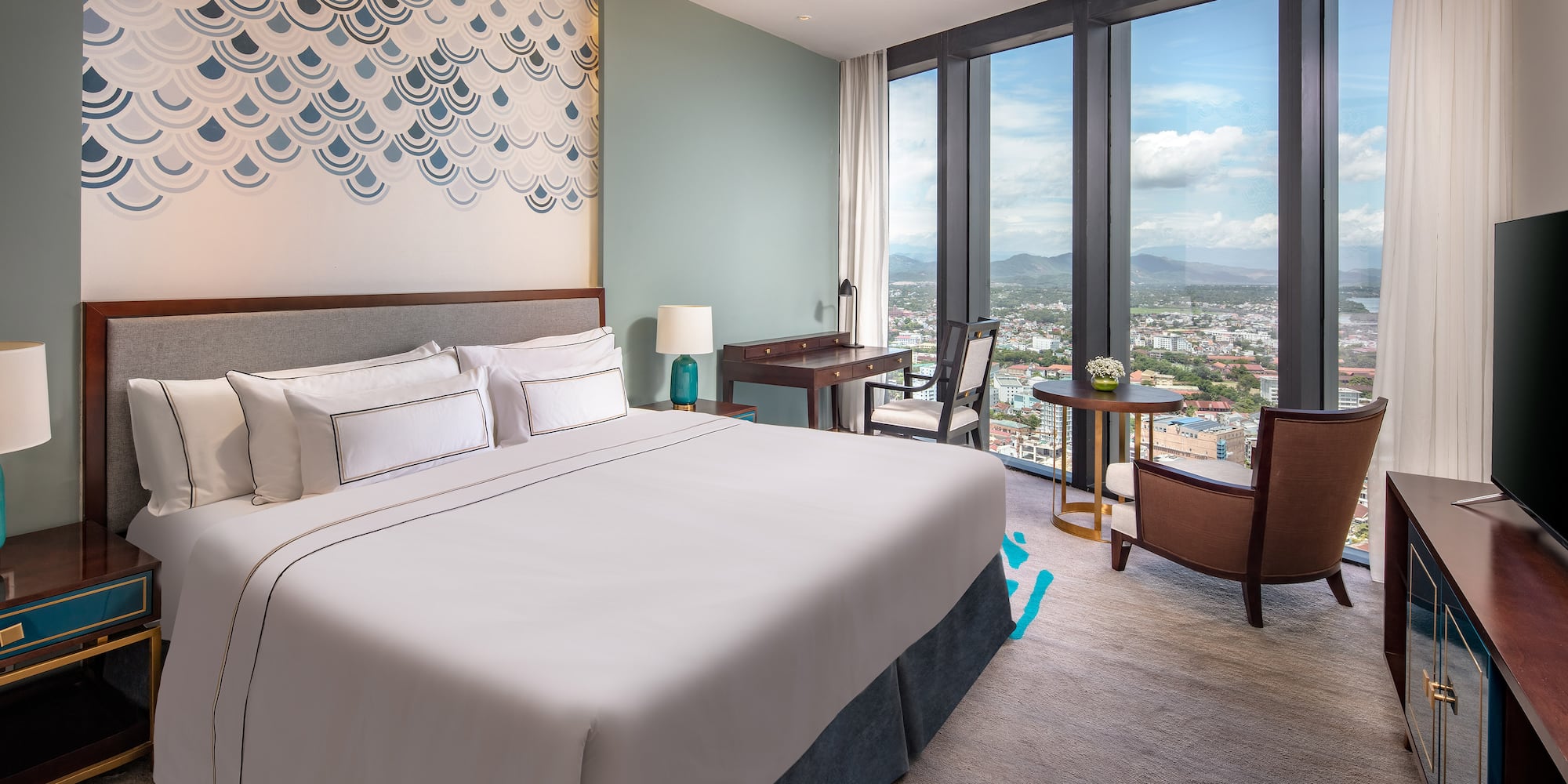 a bedroom with a large window and a large bed