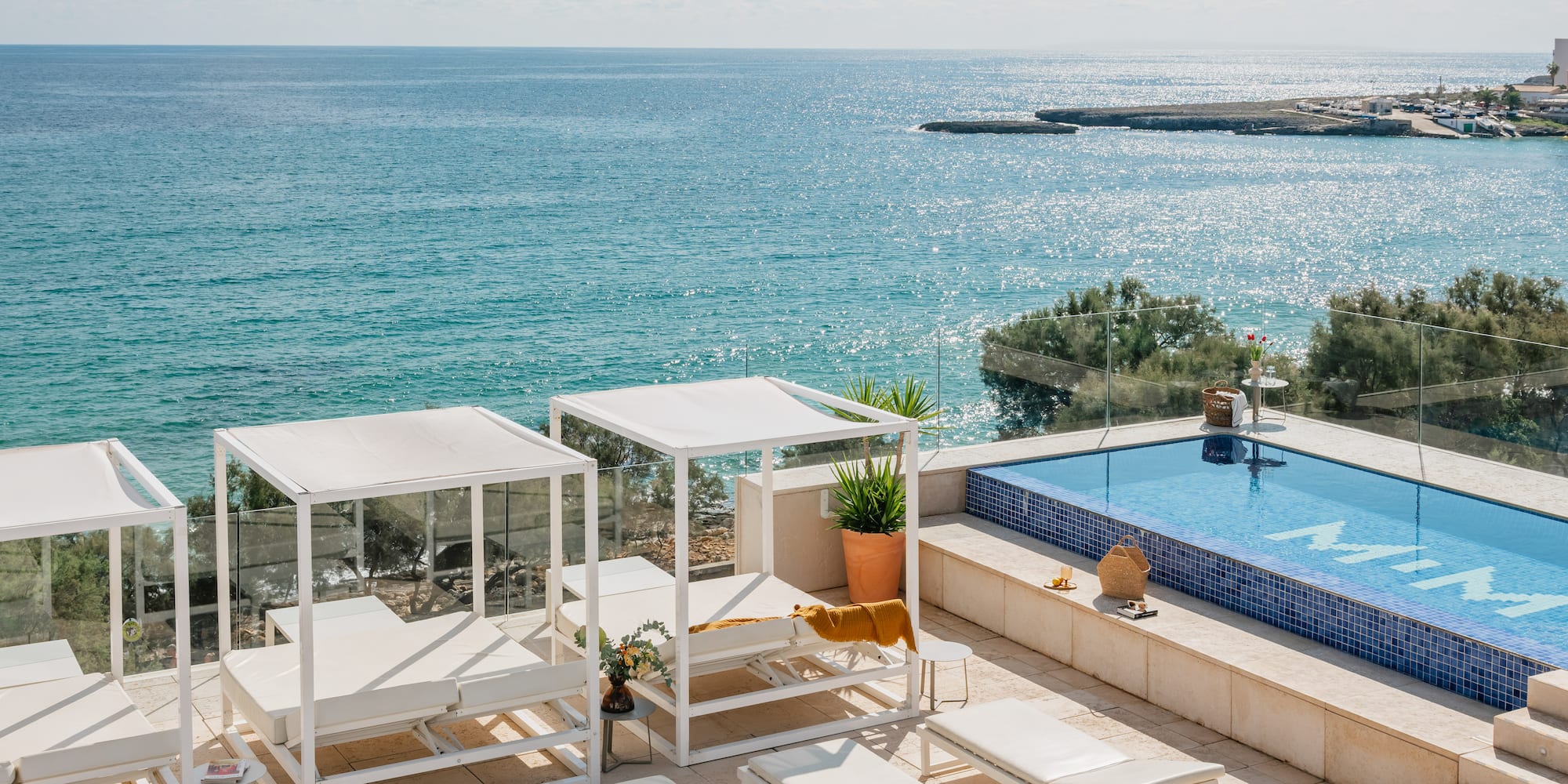 a pool with chairs and a large body of water
