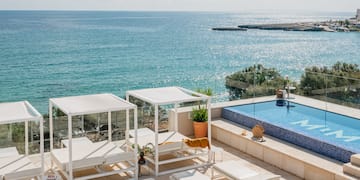 a pool with chairs and a large body of water