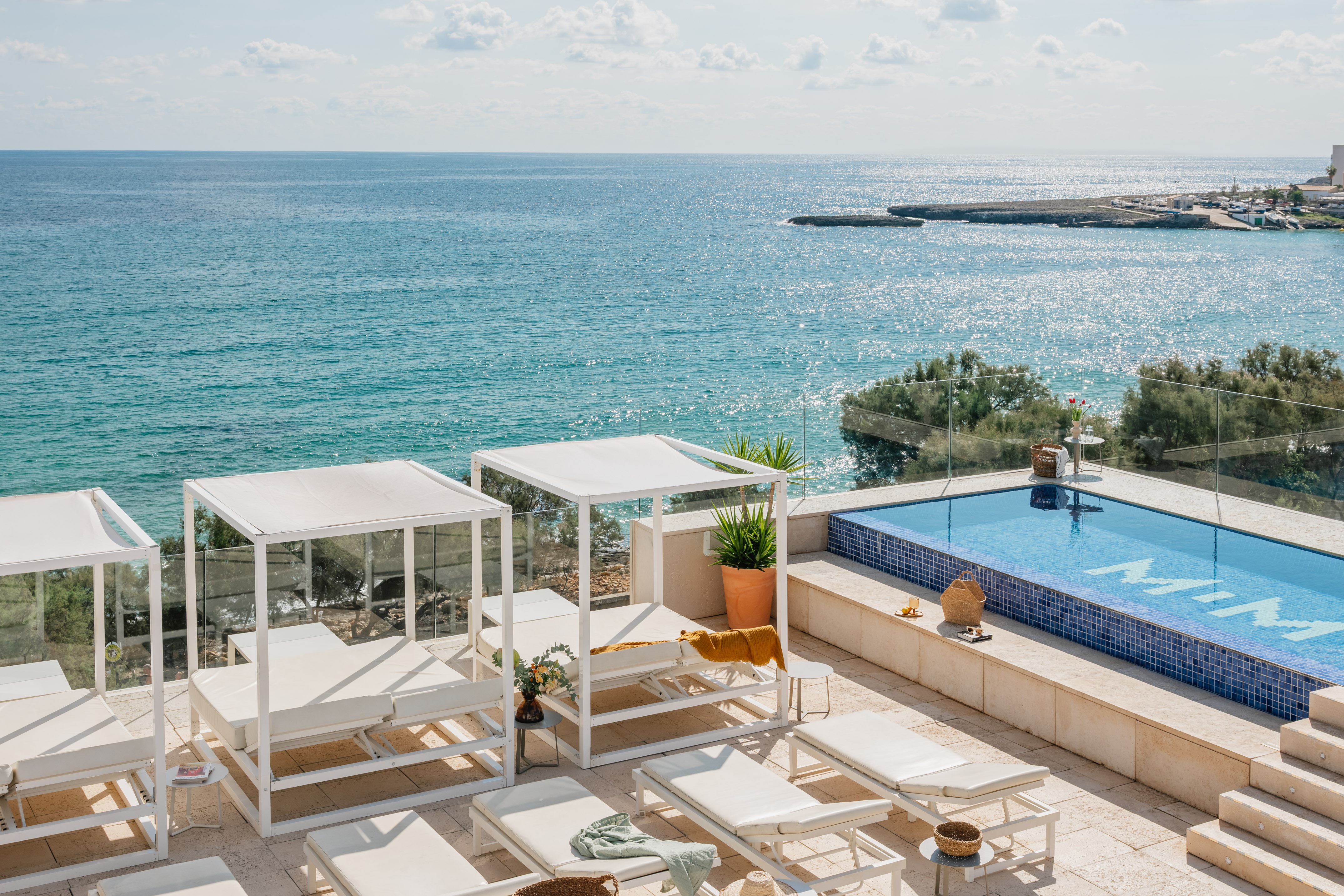 a pool with chairs and a large body of water