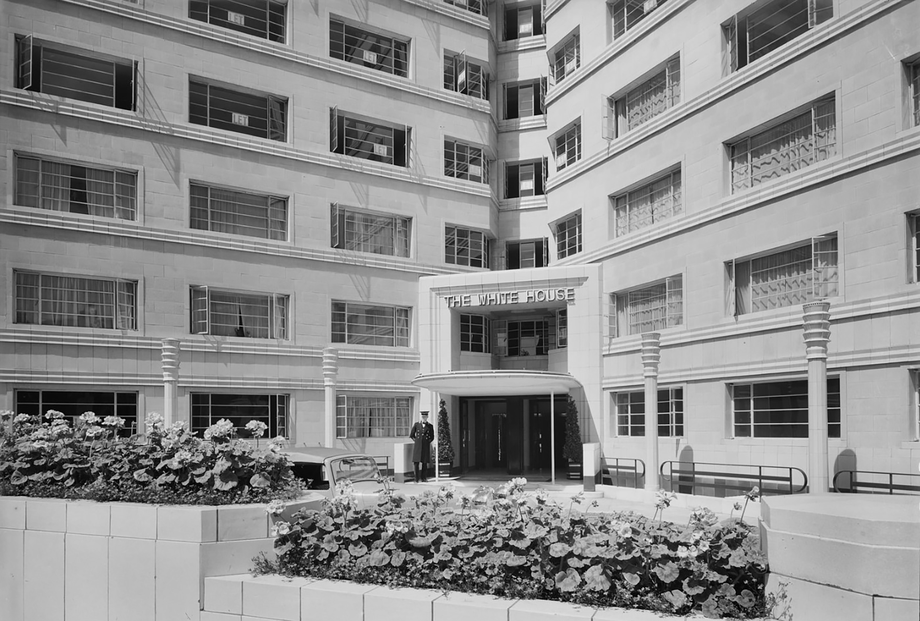 1930s Art Deco 'The White House' apartment block, doorman, flowers.