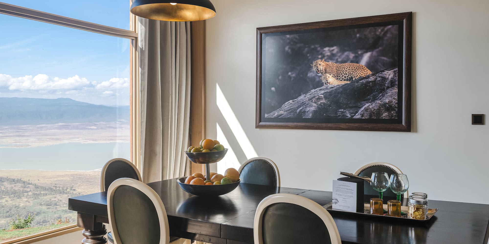 a dining table with chairs and a painting on the wall