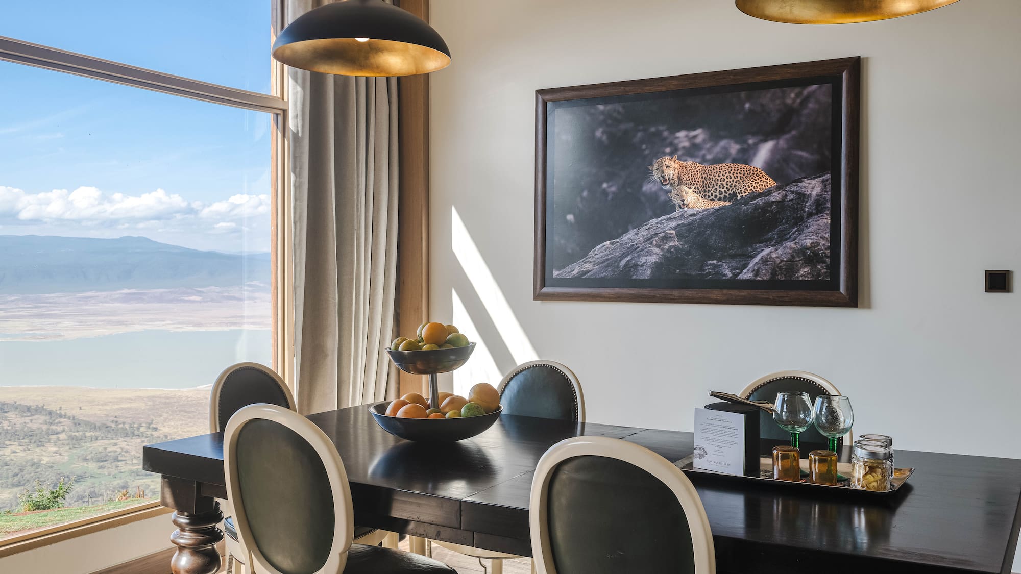 a dining table with chairs and a painting on the wall