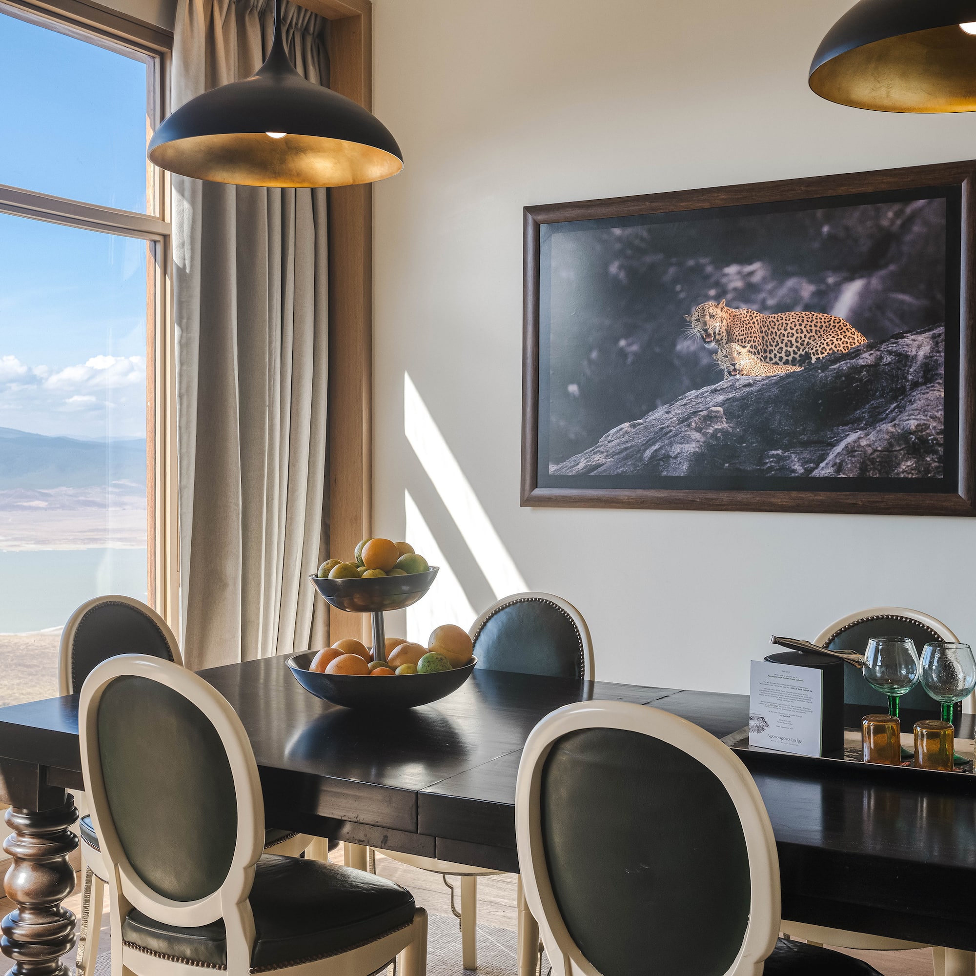 a dining table with chairs and a painting on the wall