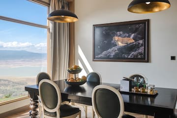 a dining table with chairs and a painting on the wall