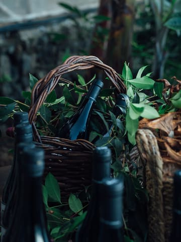 a basket of wine bottles and leaves