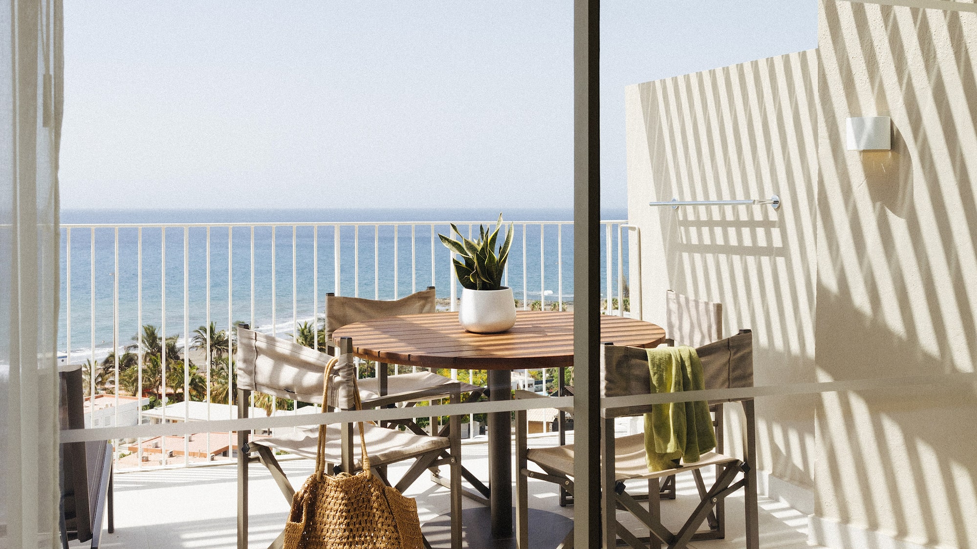 a table and chairs on a balcony overlooking a body of water