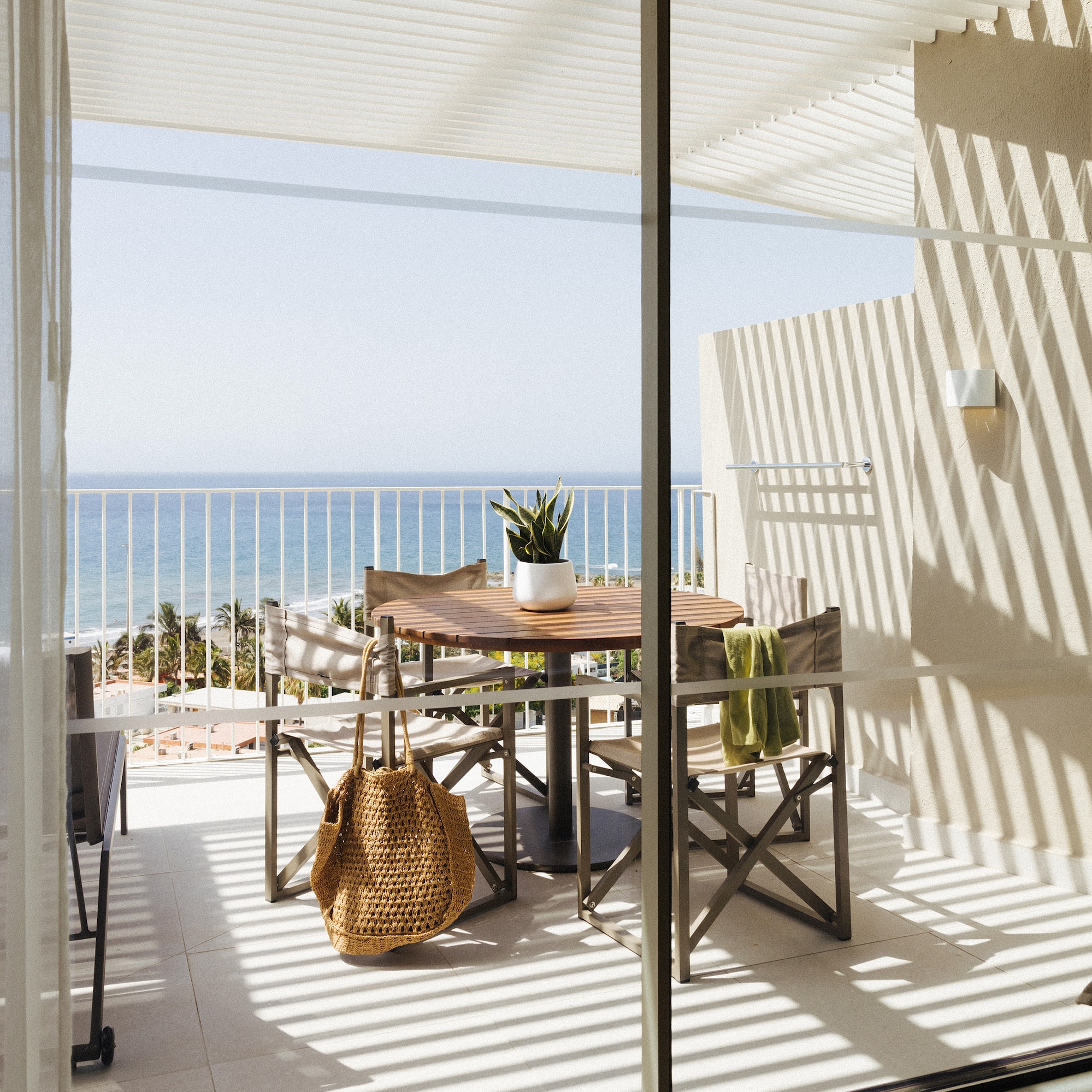 a table and chairs on a balcony overlooking a body of water
