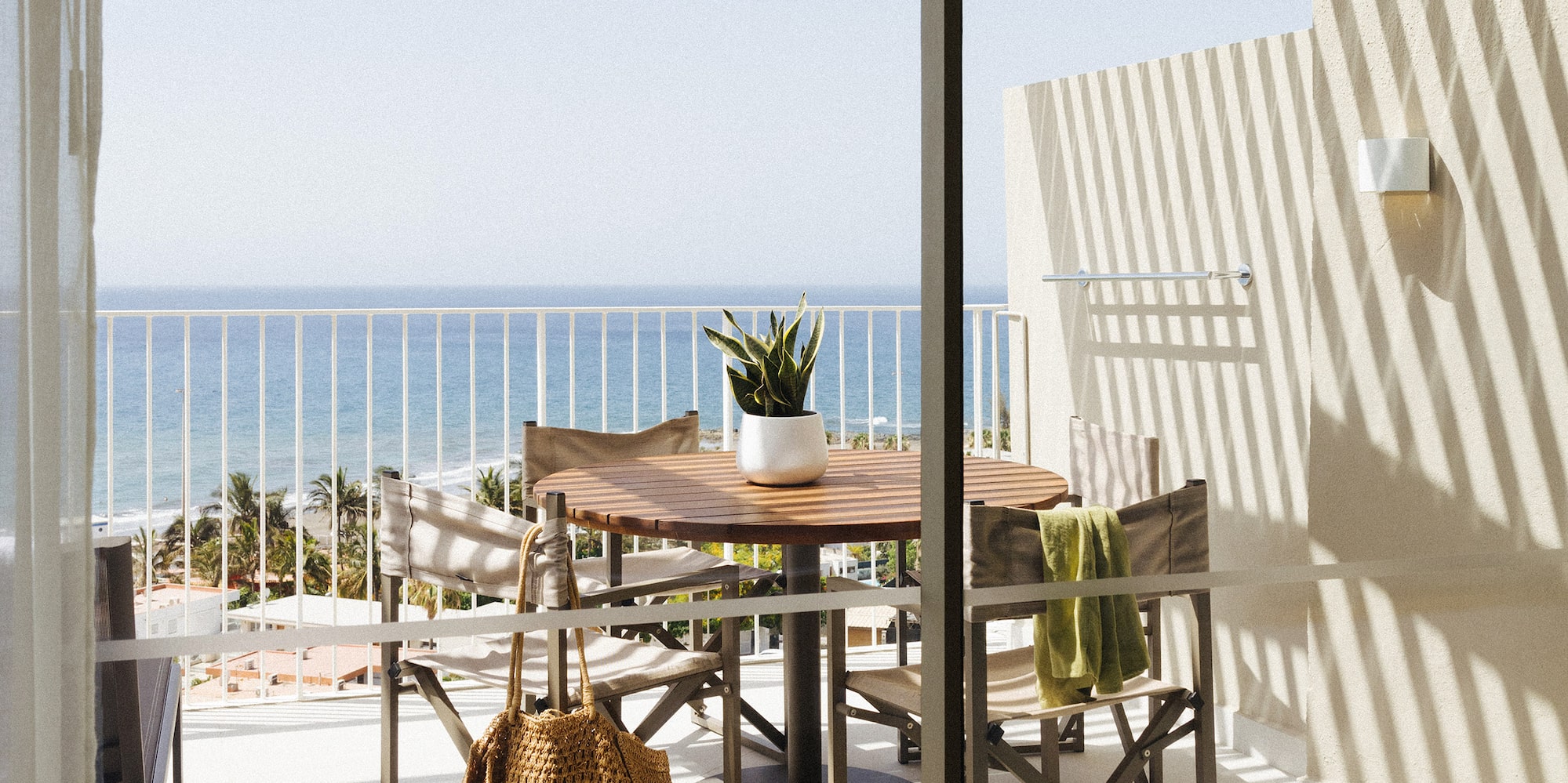 a table and chairs on a balcony overlooking a body of water