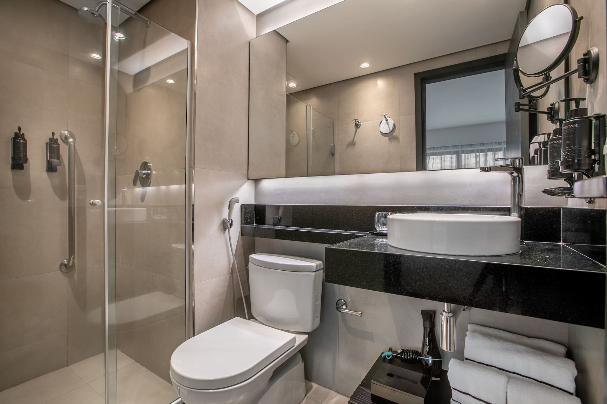 Modern hotel bathroom with glass shower, vessel sink, and toilet. - Deluxe Room Twin - Meliá Ibirapuera, São Paulo