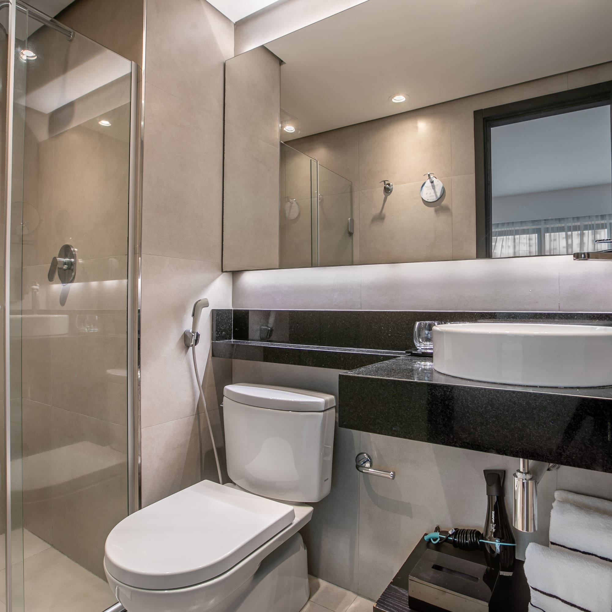 Modern hotel bathroom with glass shower, vessel sink, and toilet. - Deluxe Room Twin - Meliá Ibirapuera, São Paulo