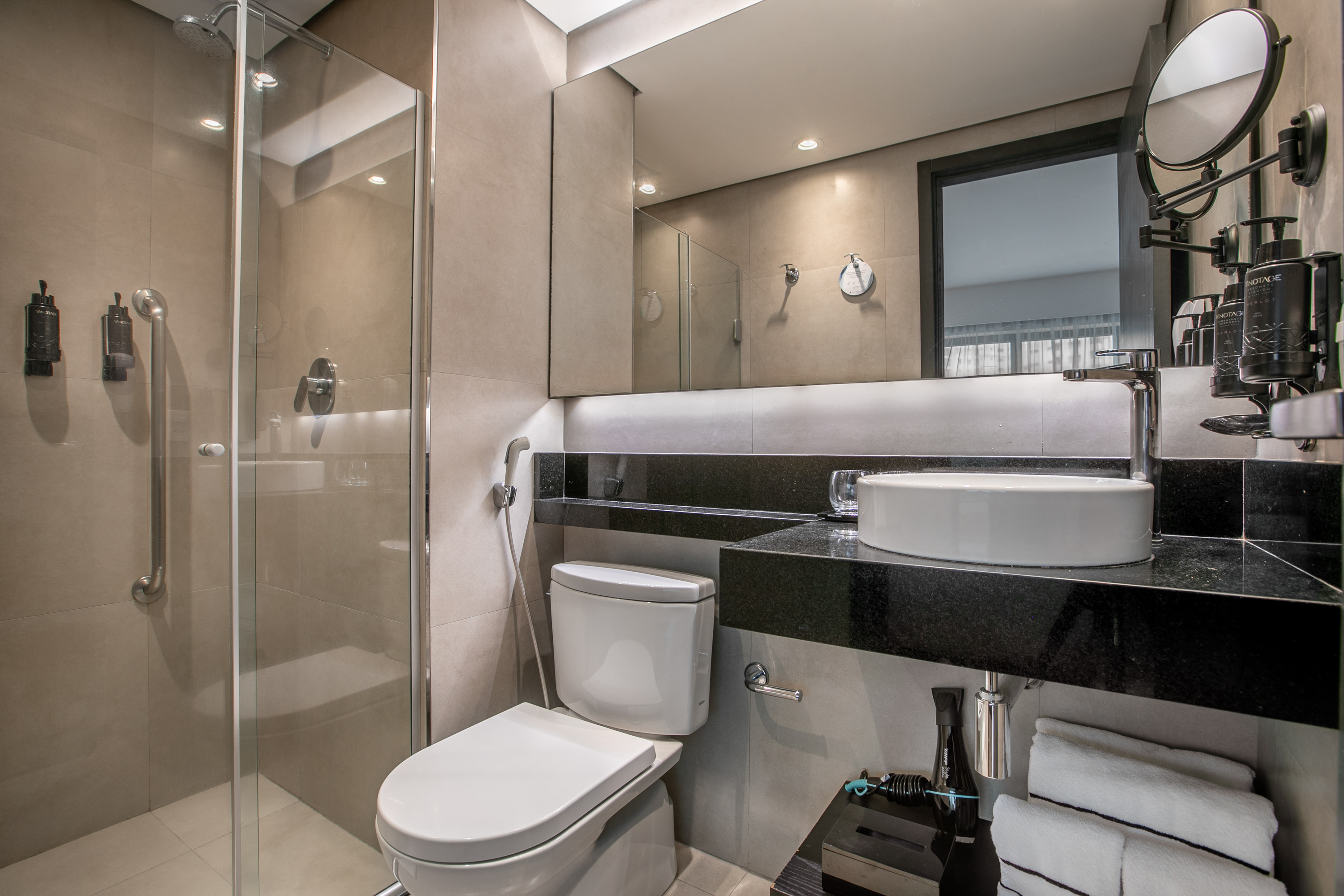 Modern hotel bathroom with glass shower, vessel sink, and toilet. - Deluxe Room Twin - Meliá Ibirapuera, São Paulo