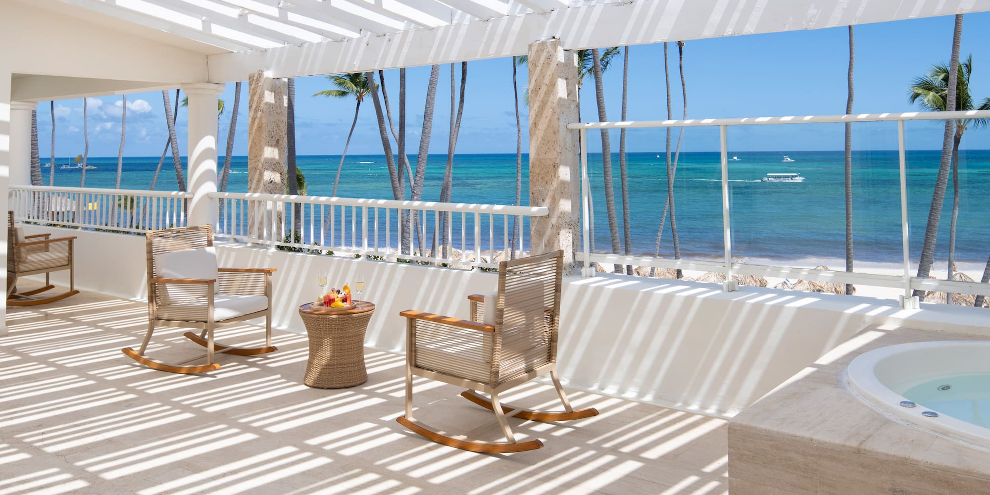 a patio with chairs and a table on a beach