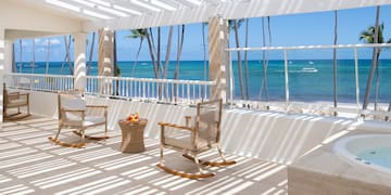 a patio with chairs and a table on a beach