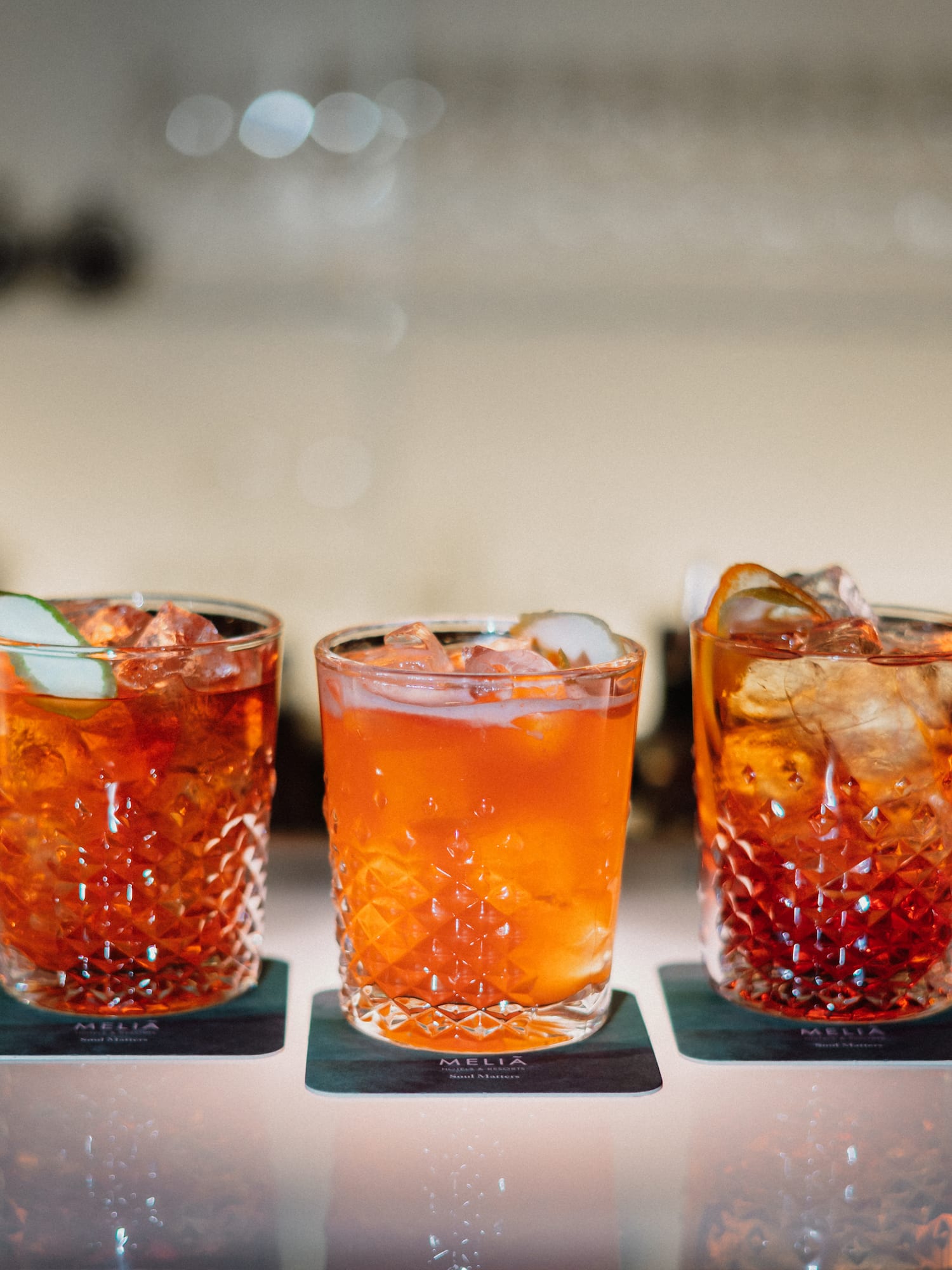 a group of glasses with orange liquid and ice