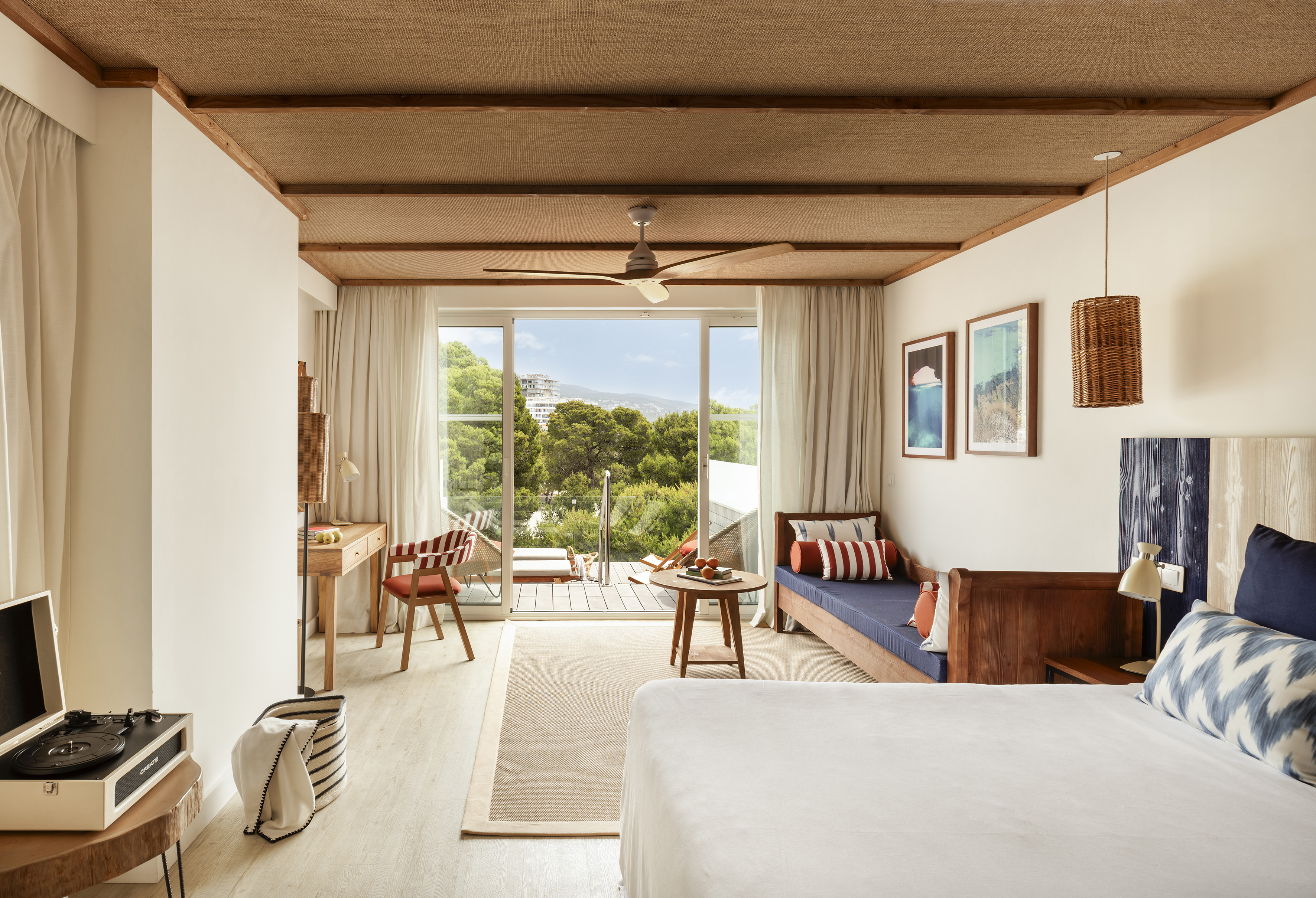 Mediterranean hotel room with balcony, forest view, and natural textures.