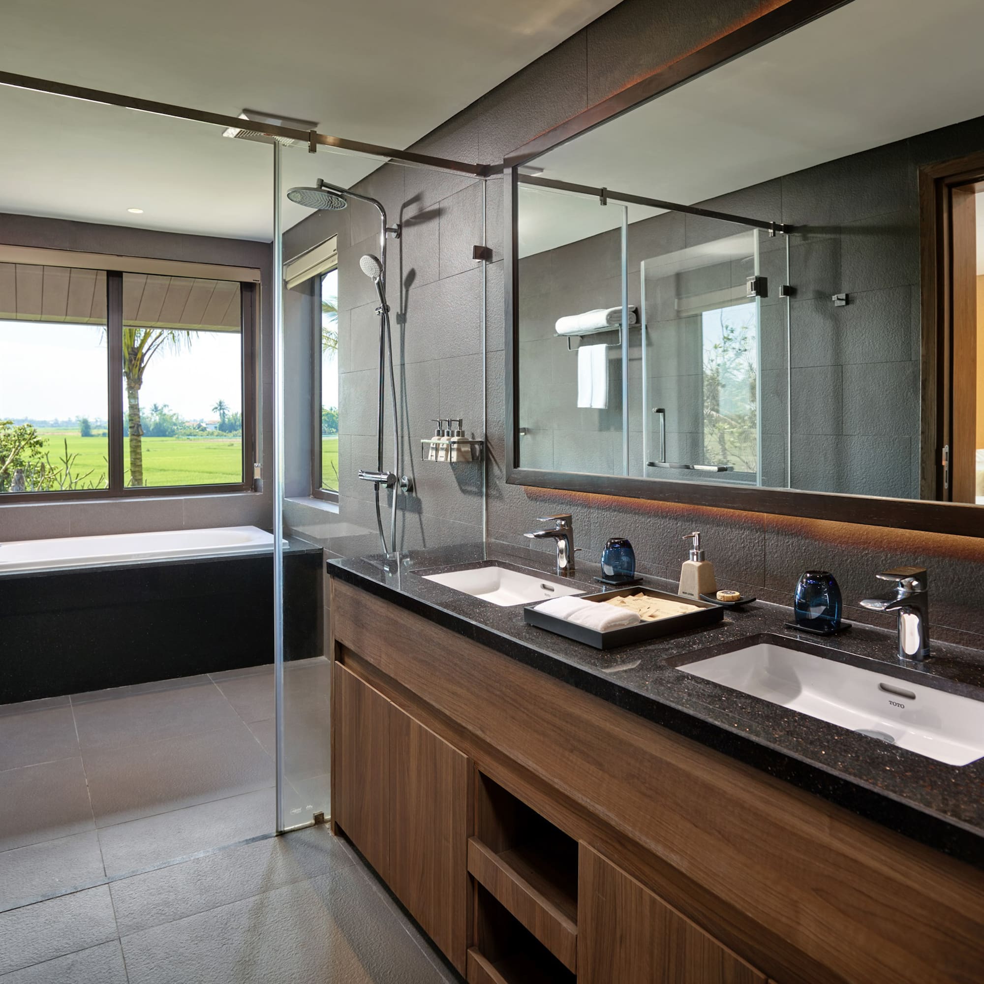 a bathroom with a large glass shower and a tub