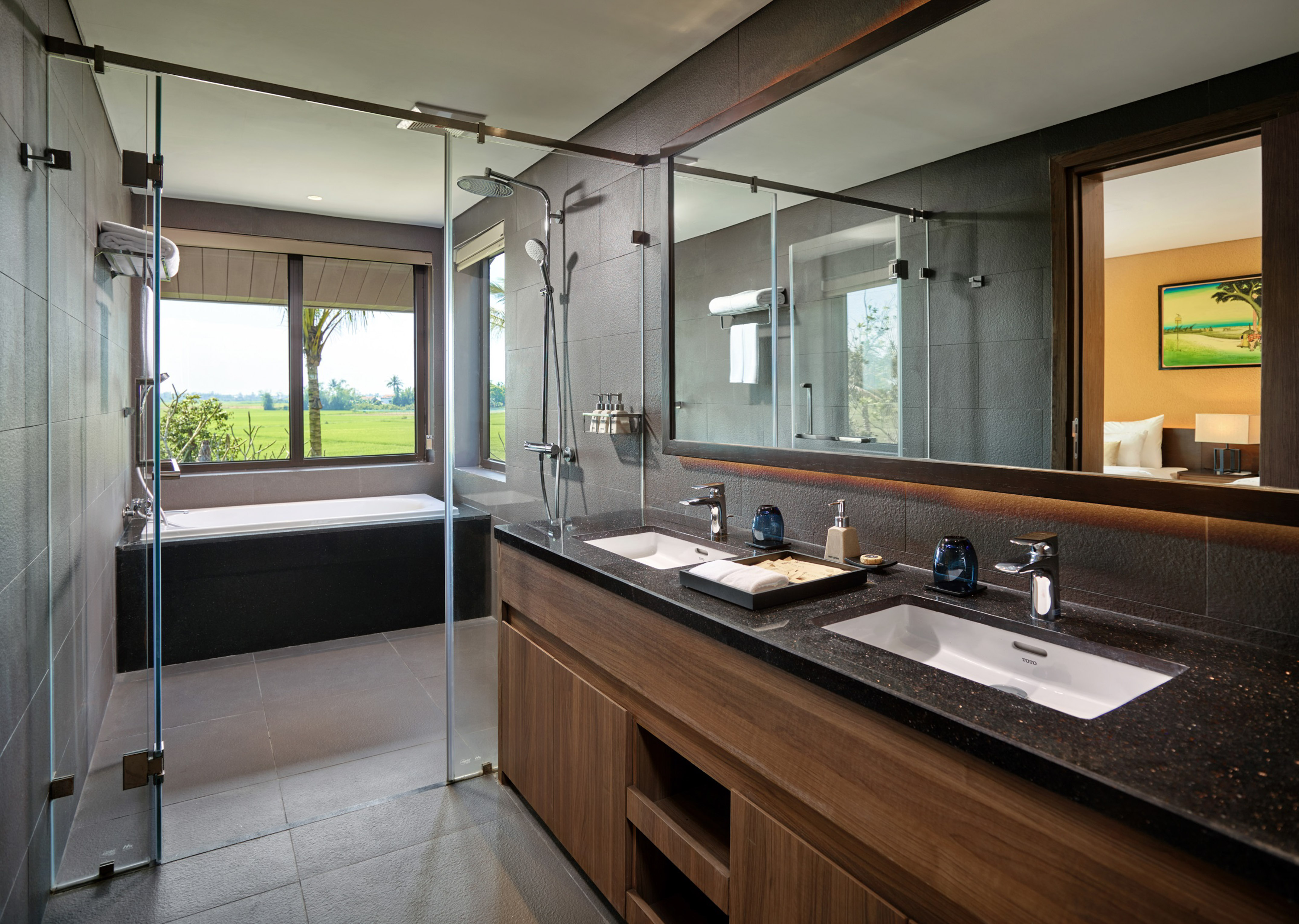 Modern bathroom with double vanity, shower, tub, and rice field view.