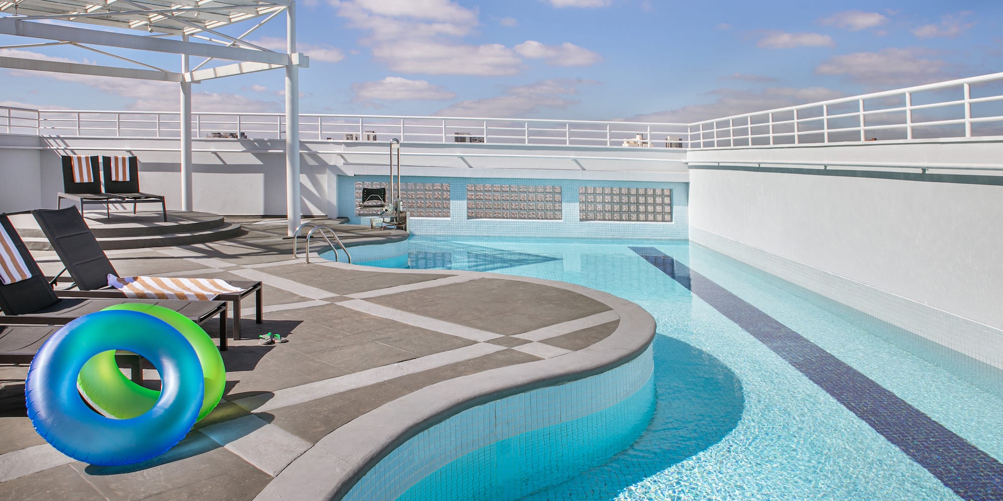 a pool with a deck chair and two colorful rubber rings