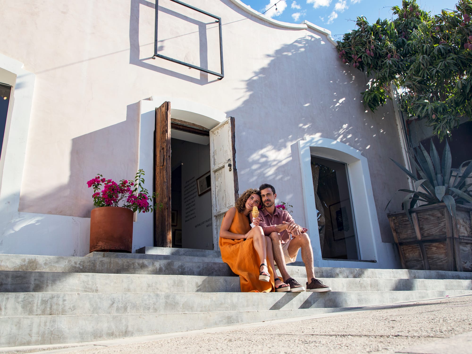 a man and woman sitting on stairs outside a building