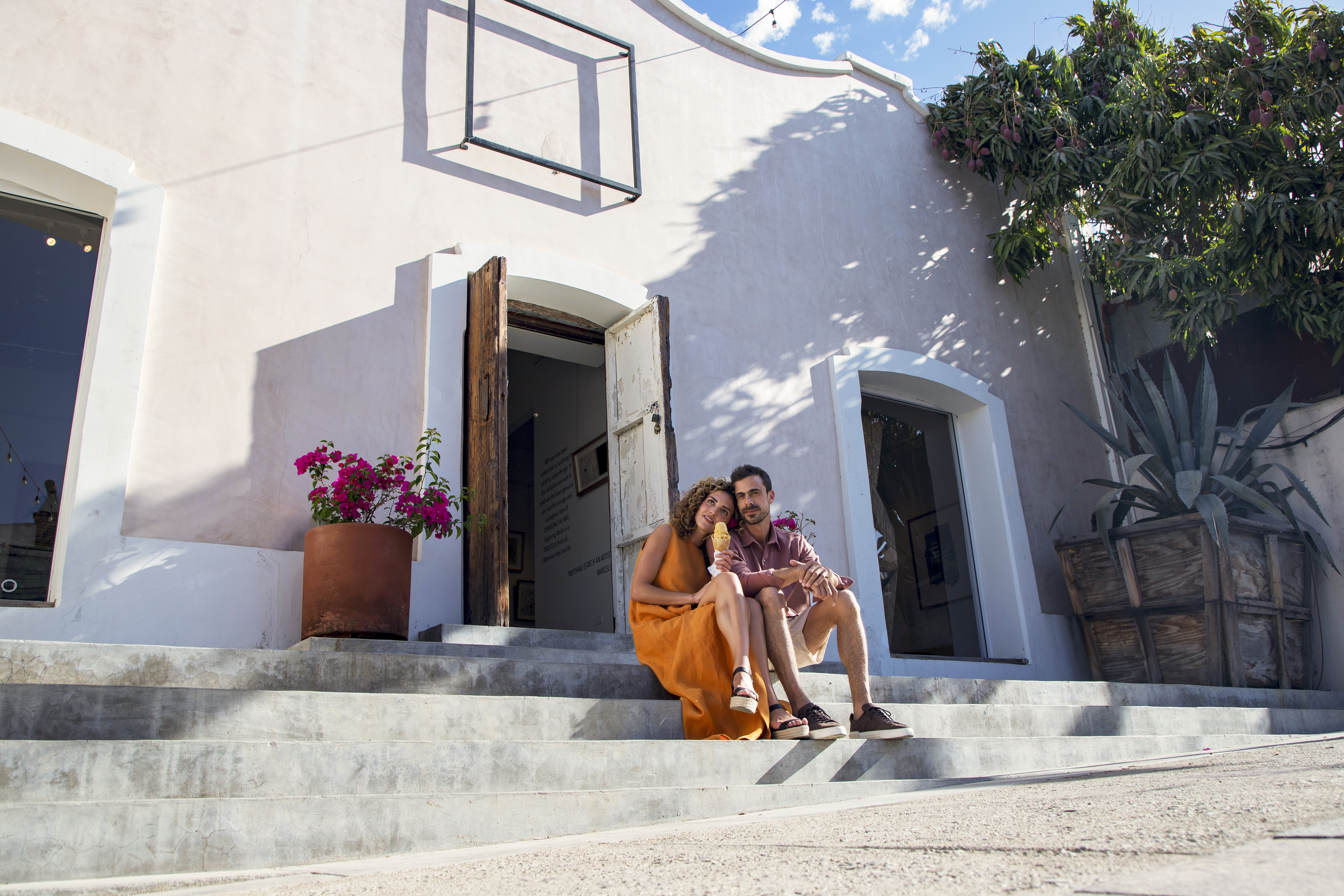 a man and woman sitting on stairs outside a building