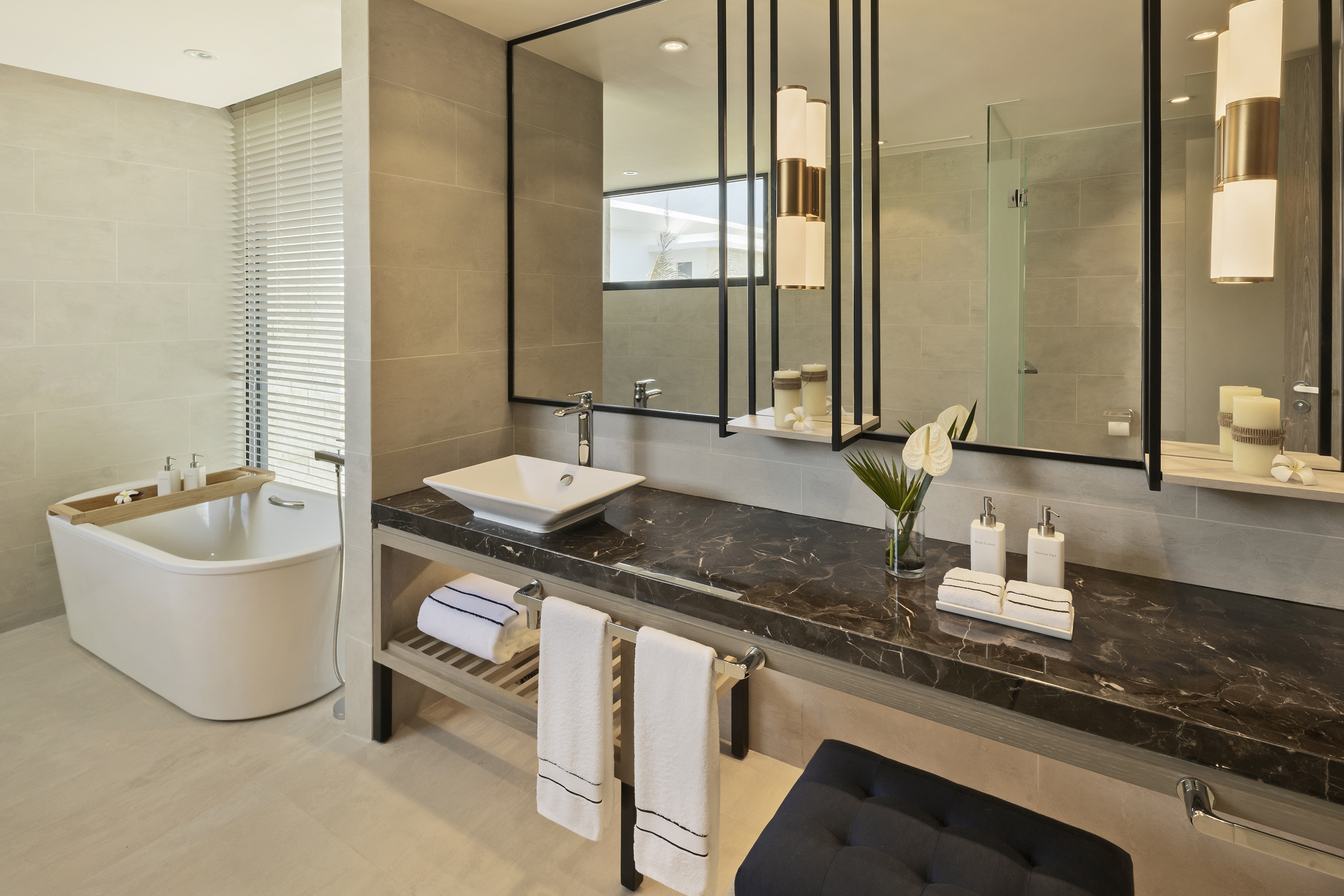Luxurious modern bathroom with freestanding bathtub, dark marble vanity, and mirror.