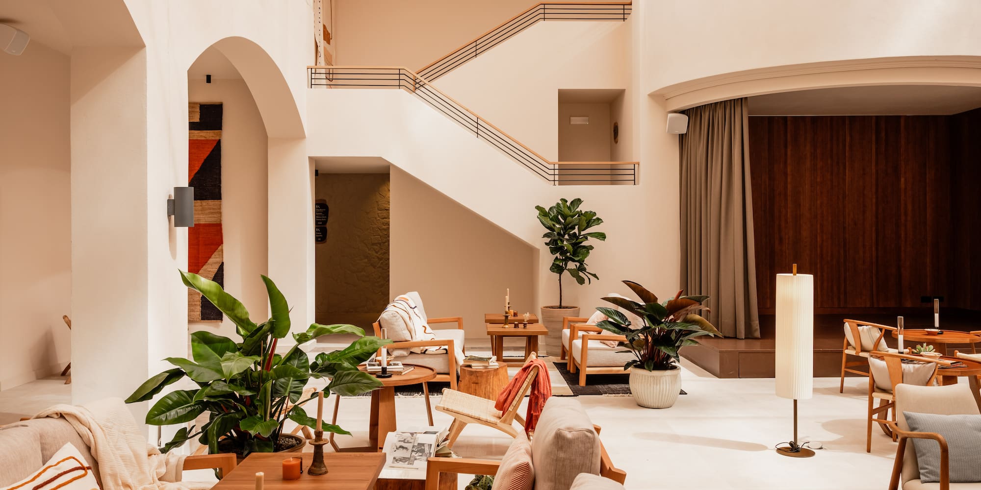 a room with a staircase and chairs and tables