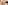 Modern hotel lobby lounge with wooden furniture, lush plants, and a grand staircase.