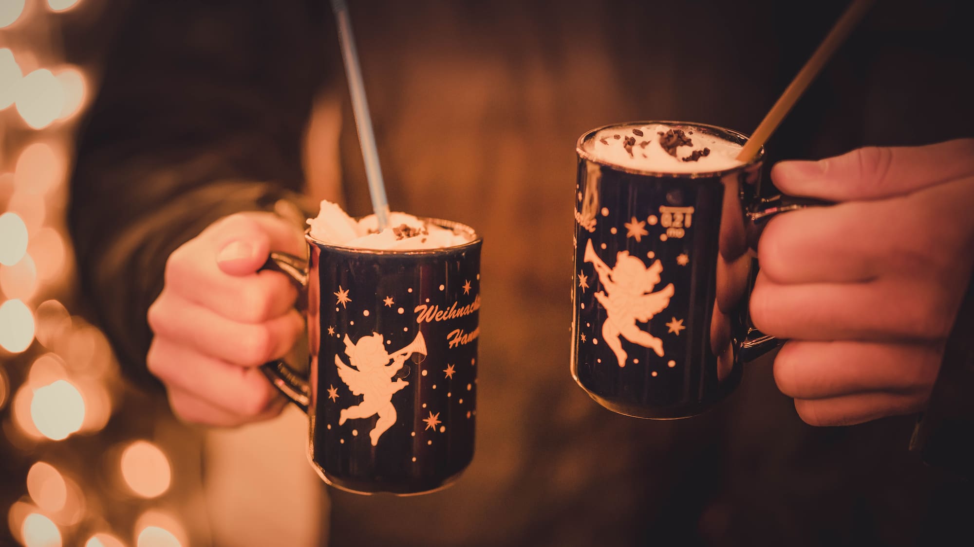 two hands holding cups with drinks